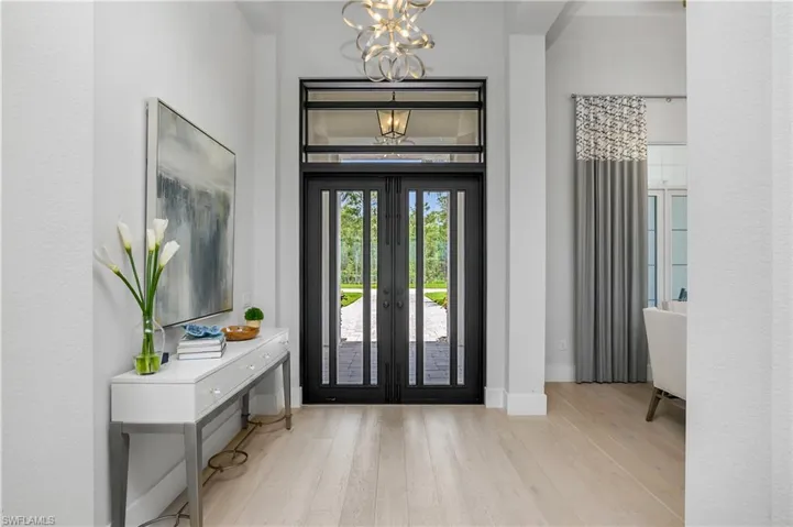 Entryway with light hardwood / wood-style floors and a chandelier