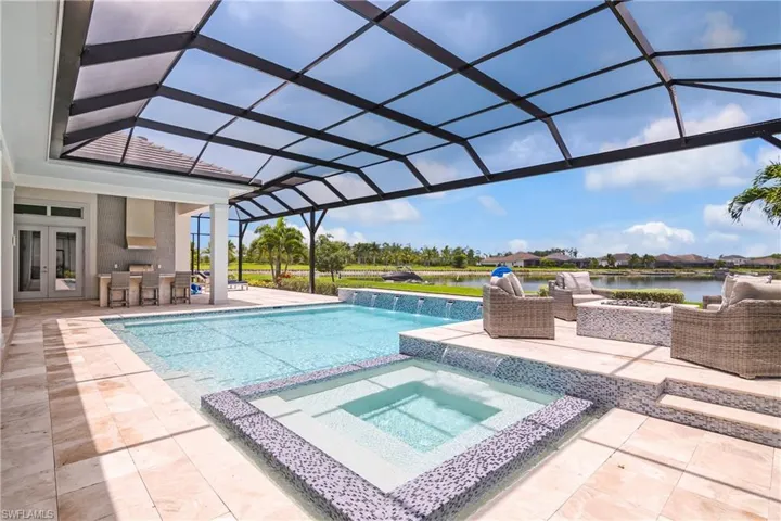 View of swimming pool featuring a water view, a patio, an in ground hot tub, a lanai, and pool water feature