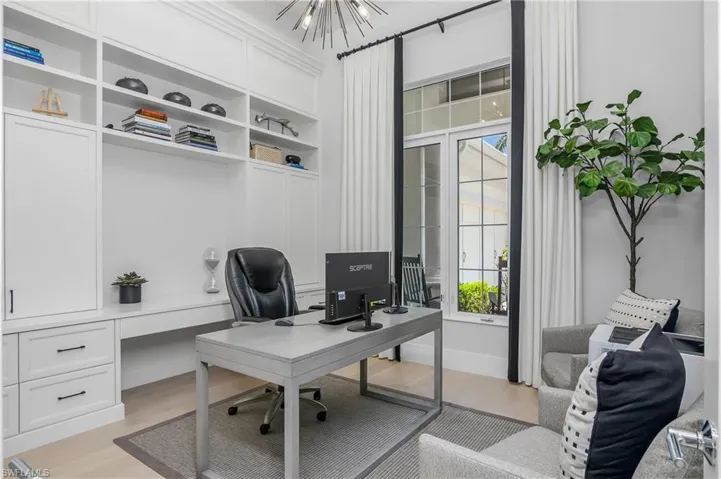 Office with custom lighting, window treatments, and built-in cabinetry.