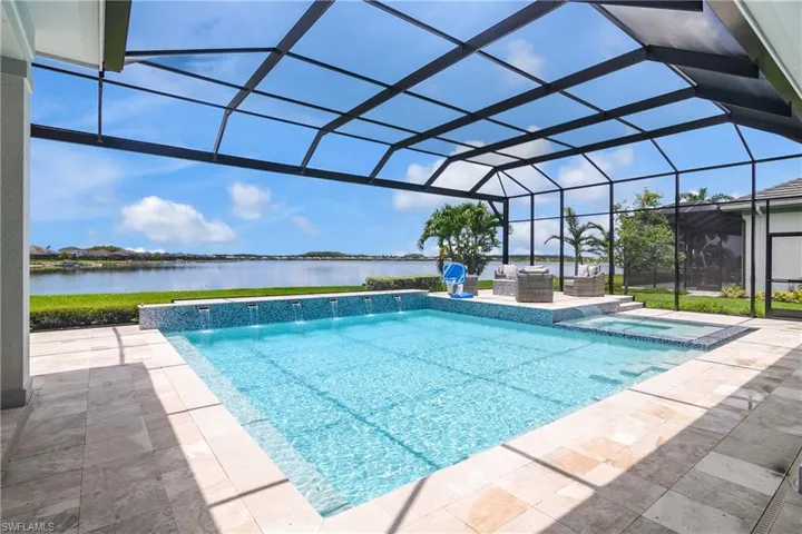 View of swimming pool with a water view, a patio, glass enclosure, an in ground hot tub, and pool water feature