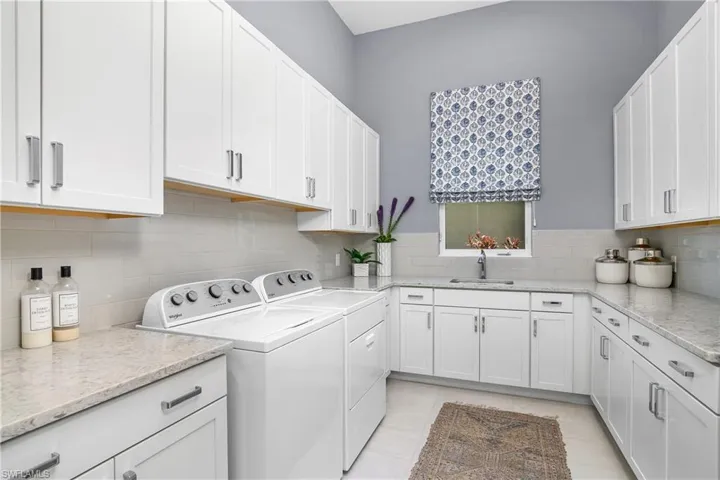 What a laundry room! So much additional storage space, a utility sink, and a window providing plenty of natural light.