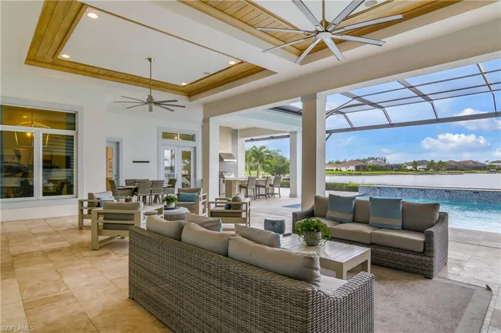 View of patio / terrace with a water view, an outdoor hangout area, glass enclosure, and ceiling fan
