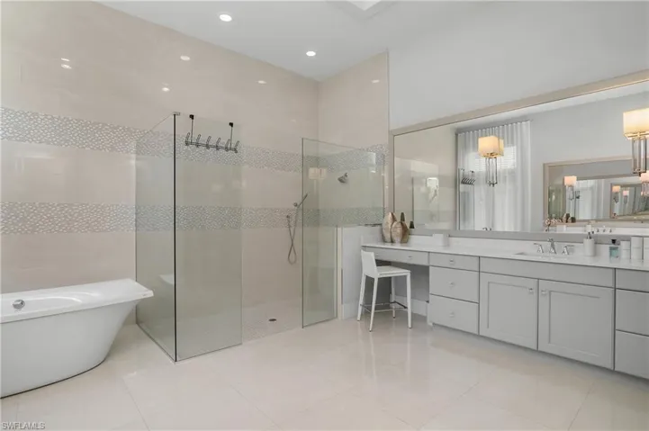 Bathroom featuring tile patterned floors, vanity, and plus walk in shower