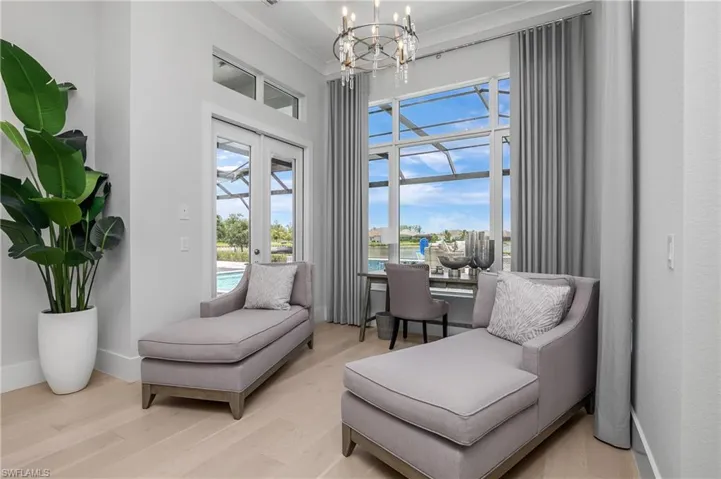 Living area featuring french doors, ornamental molding, a chandelier, and light hardwood / wood-style floors