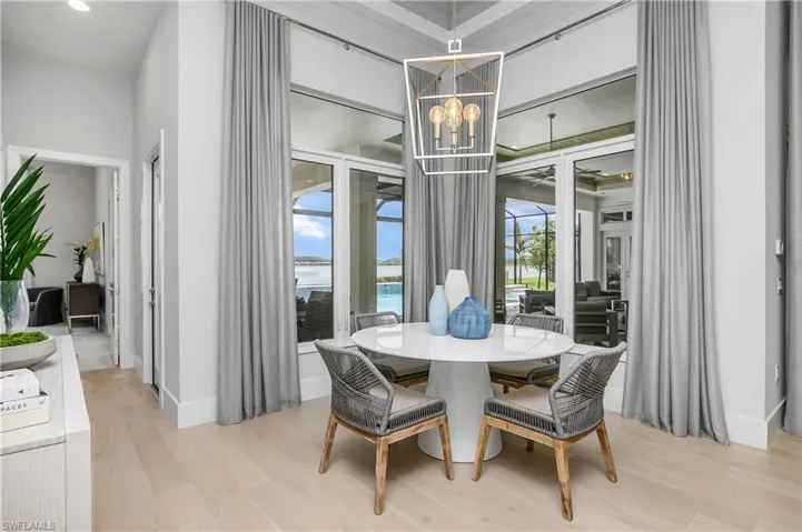Dining room with a water view, an inviting chandelier, and light hardwood / wood-style flooring