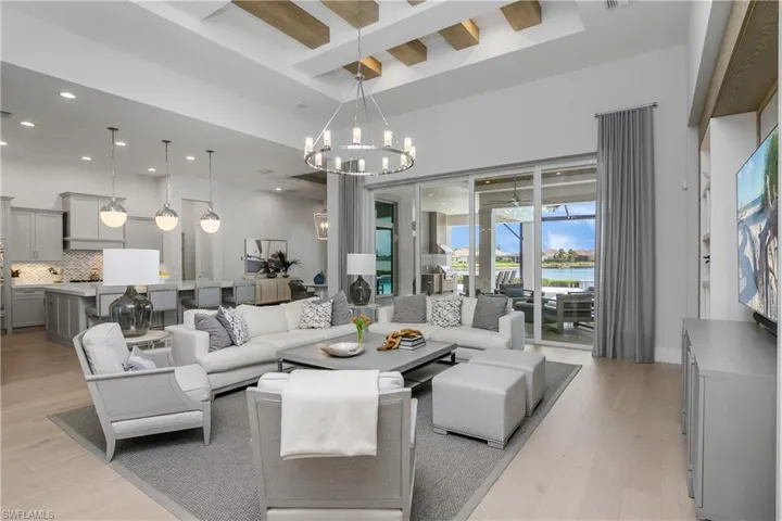 Living room featuring a notable chandelier, beam ceiling, and light hardwood / wood-style flooring