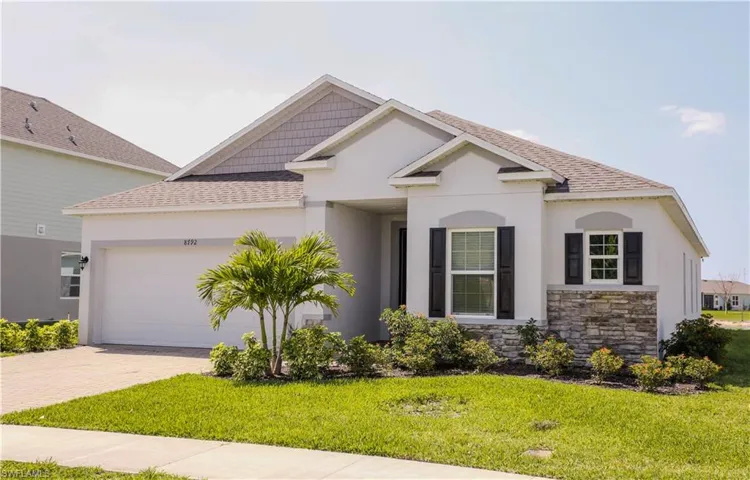 View of front facade with a shingled roof, a front yard, a garage, and stucco siding