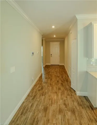 Hall featuring crown molding, recessed lighting, and light wood finished floors
