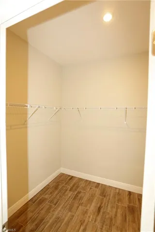 Walk in closet featuring wood finish floors