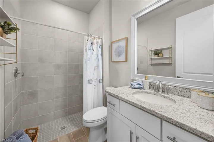 Full bath with vanity and tiled shower