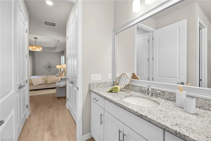 Ensuite bathroom featuring vanity and wood finished floors