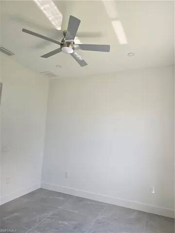 Tiled empty room with ceiling fan