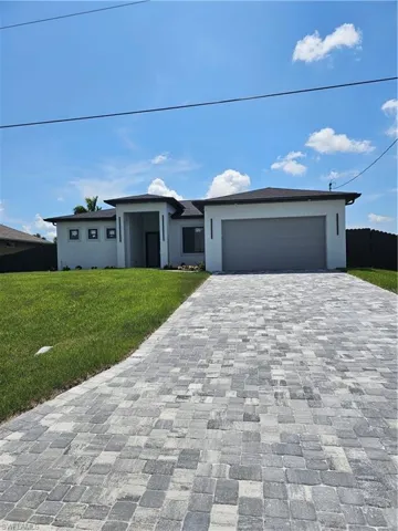 View of front facade with a garage and a front lawn