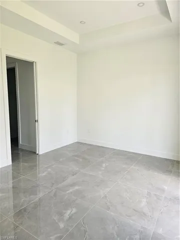 Spare room featuring tile floors and a tray ceiling