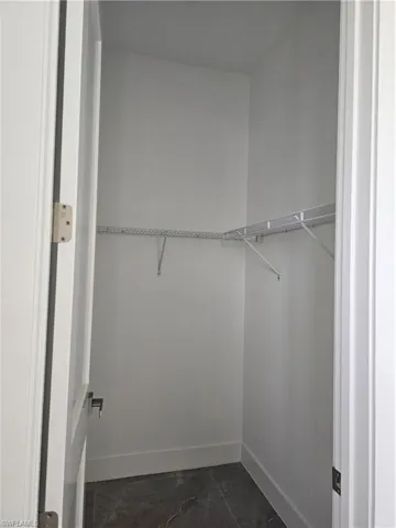 Spacious closet with dark tile flooring
