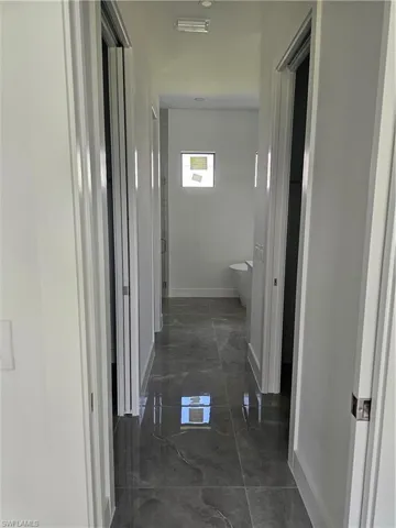 Hallway with dark tile floors