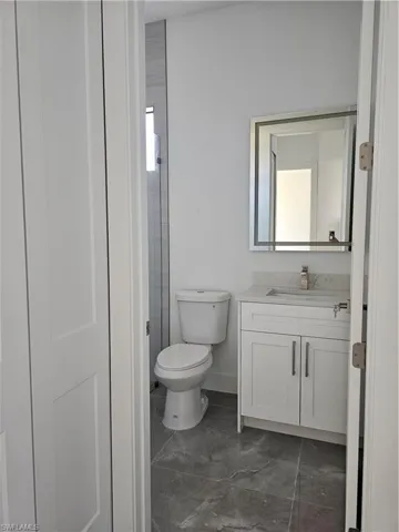 Bathroom featuring vanity, toilet, and tile floors