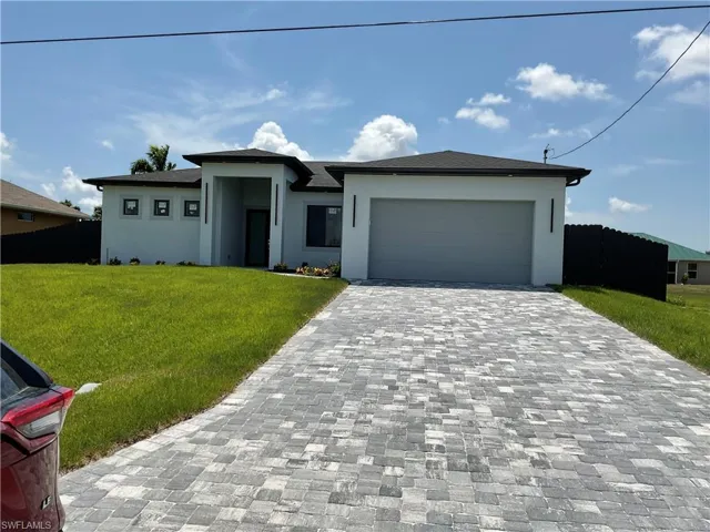 View of front of home with a front yard and a garage