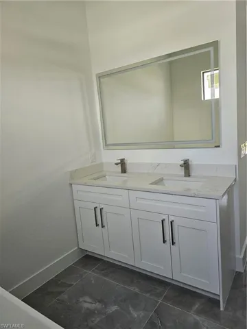 Bathroom with double vanity and tile floors