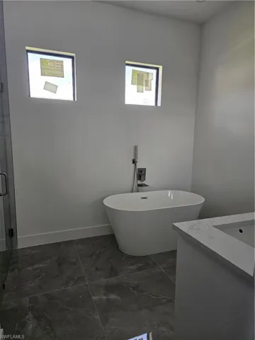 Bathroom with tile flooring, vanity, and a bathtub