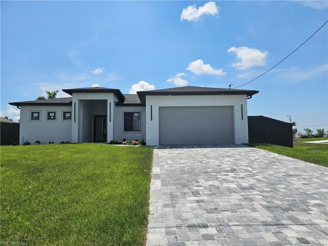 View of front of house featuring a garage and a front lawn