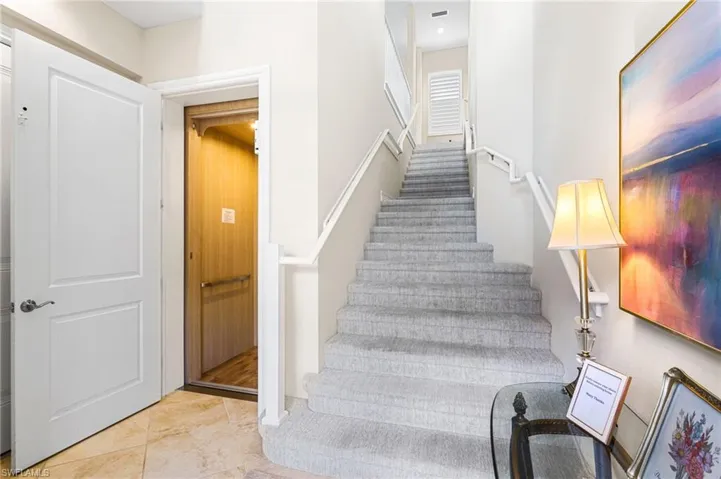 Staircase with tile patterned flooring and elevator