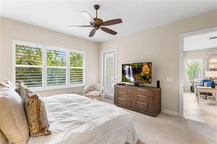 Carpeted bedroom with a ceiling fan and baseboards