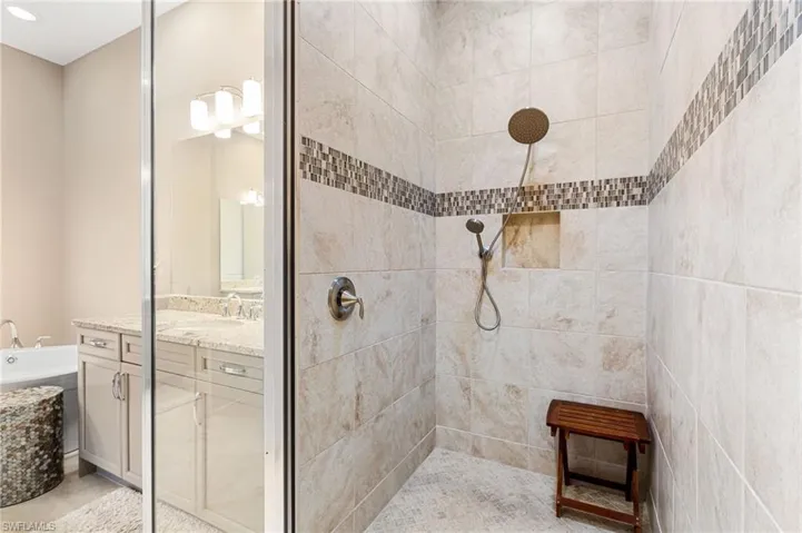Full bath featuring vanity, a tile shower, and a garden tub