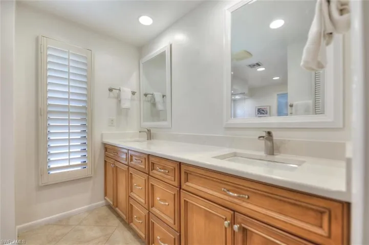 Ensuite bathroom featuring healthy amount of natural light, a marble finish shower, recessed lighting, and tile patterned floors