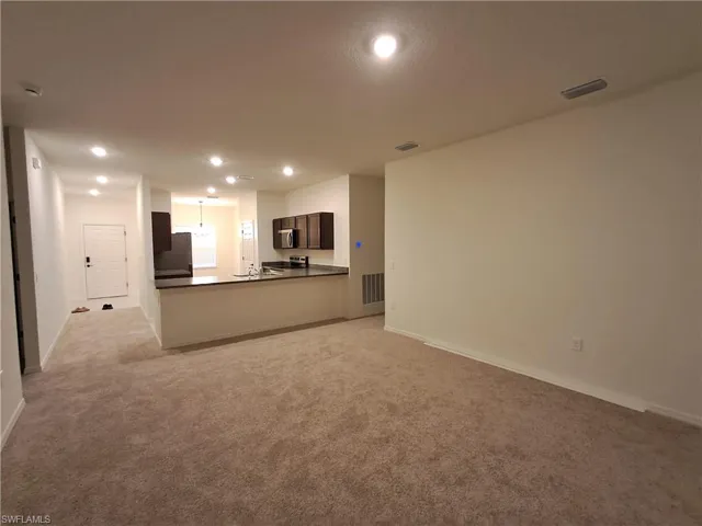 Unfurnished living room with light carpet and recessed lighting