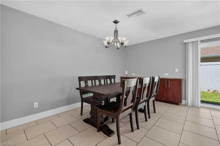 Neutral tone walls, recessed lighting, tile flooring, built-in cabinetry with stone countertops, and a glass sliding door
