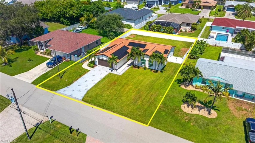Single-story residence featuring a tile roof, solar panels, and an attached garage