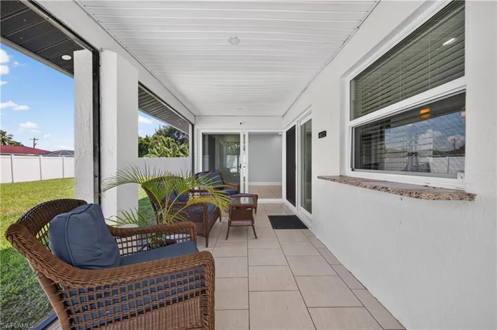 Screened patio featuring tile flooring and a textured wall with a stone sill