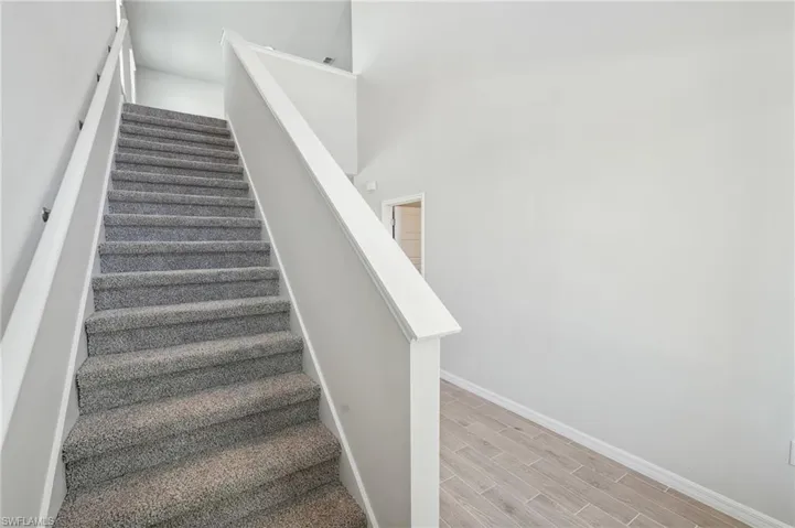 Staircase featuring wood finished floors and baseboards