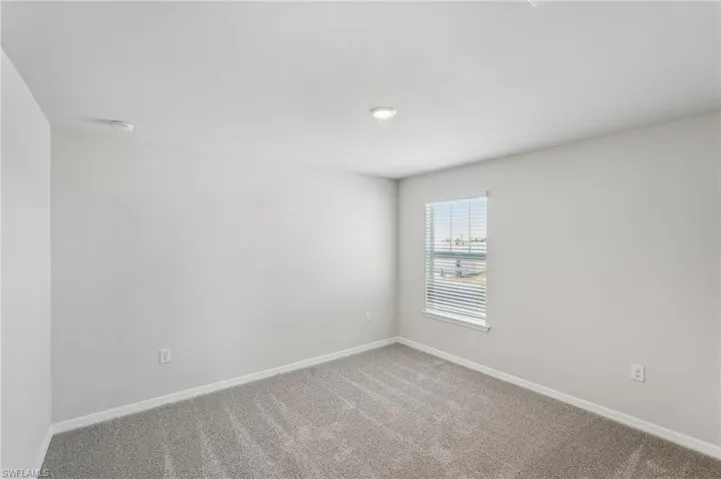 Unfurnished room with baseboards and carpet