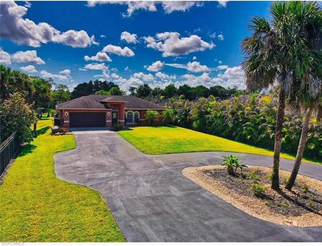 View of front of property featuring a front yard and a garage