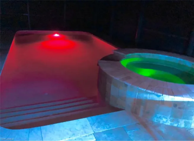 View of swimming pool with an in ground hot tub