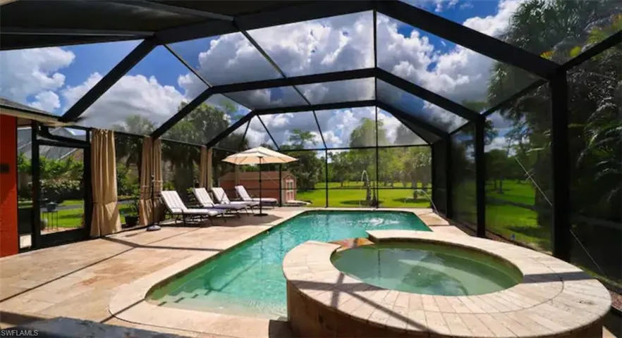 View of pool with a lanai, a patio, and an in ground hot tub