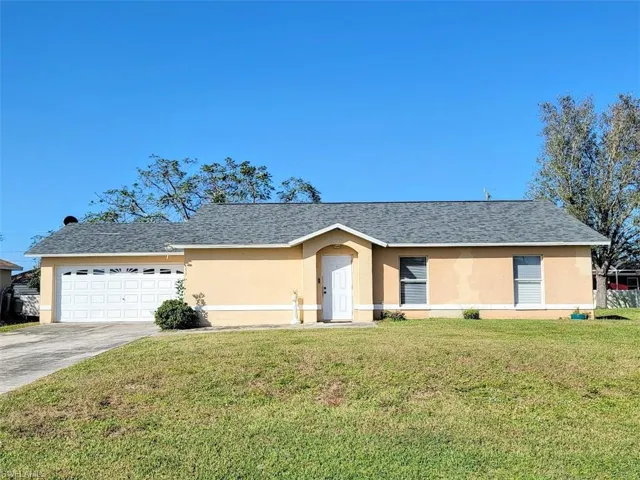 Ranch-style home with a garage and a front lawn