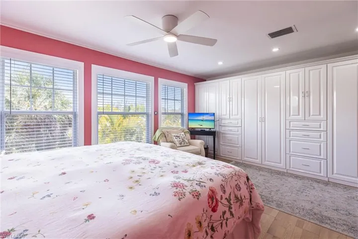 Bedroom featuring ceiling fan, visible vents, crown molding, recessed lighting, and light wood-style flooring