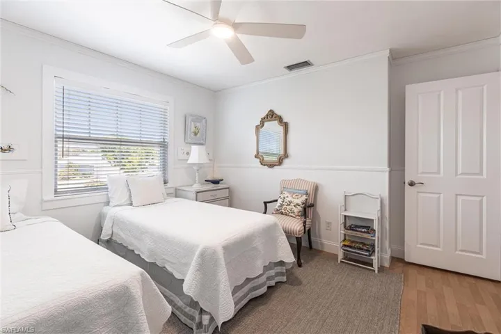 Bedroom featuring crown molding, visible vents, and light wood-style flooring