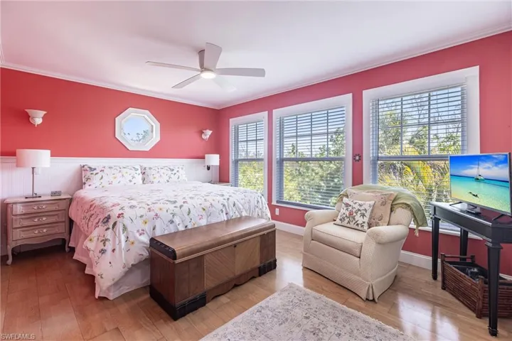 Bedroom featuring ornamental molding, a ceiling fan, and wood finished floors