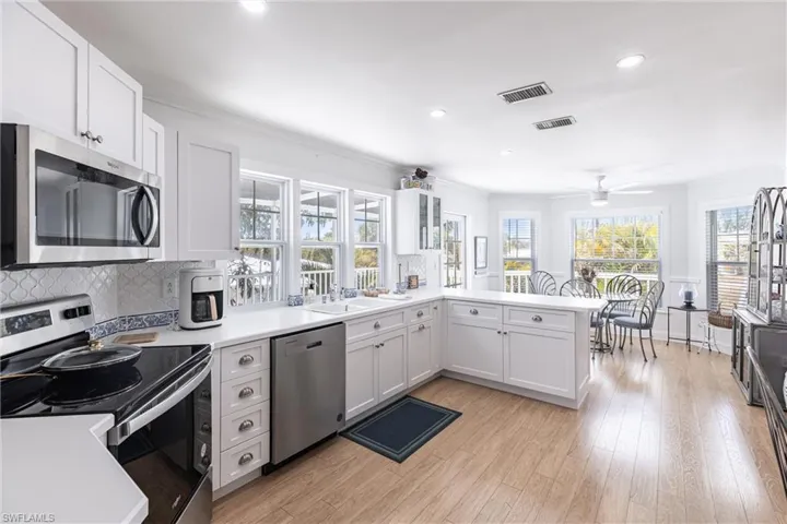 Kitchen with a ceiling fan, visible vents, appliances with stainless steel finishes, a sink, and a peninsula