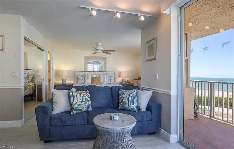 Bedroom with a closet, access to outside, track lighting, and a water view