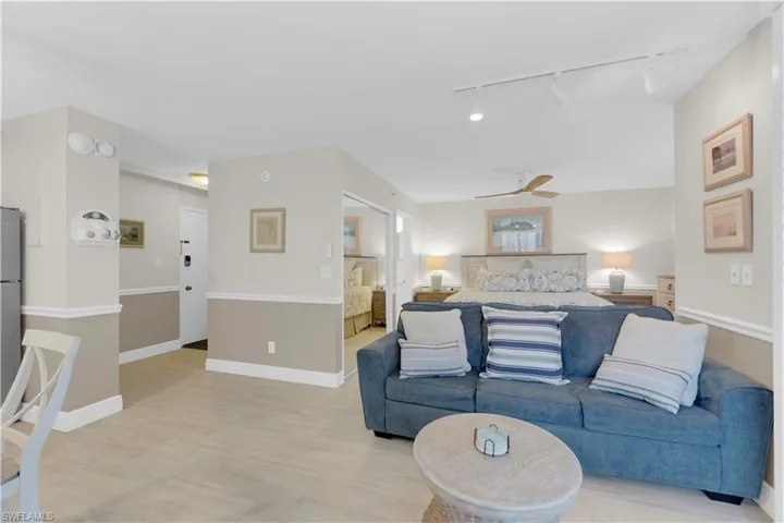 Living room featuring rail lighting and ceiling fan