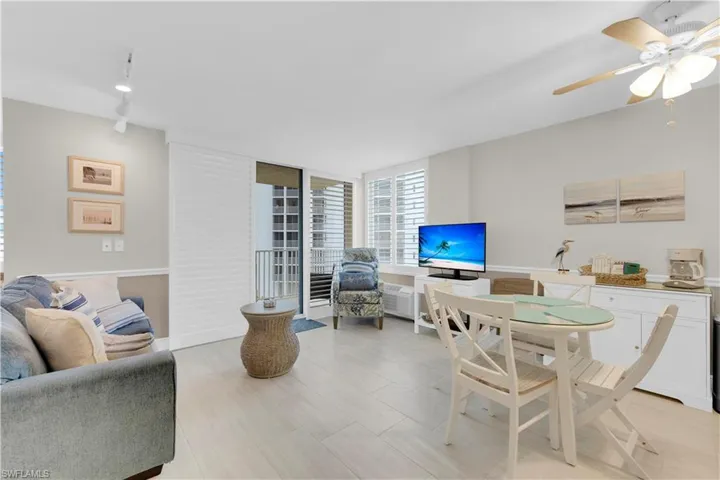 Living area featuring a ceiling fan, floor to ceiling windows, and light wood-style flooring