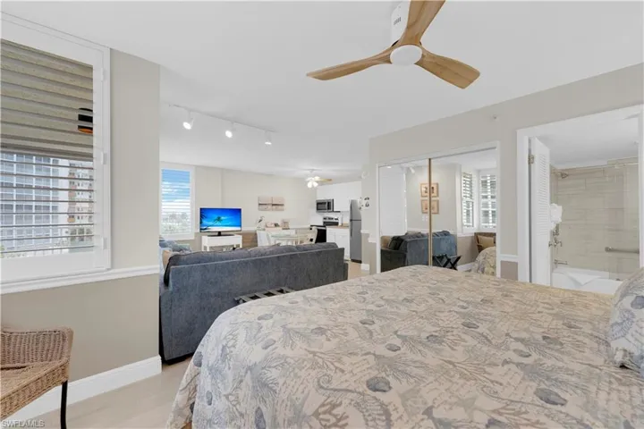 Bedroom featuring light wood-style floors, a closet, a ceiling fan, rail lighting, and freestanding refrigerator