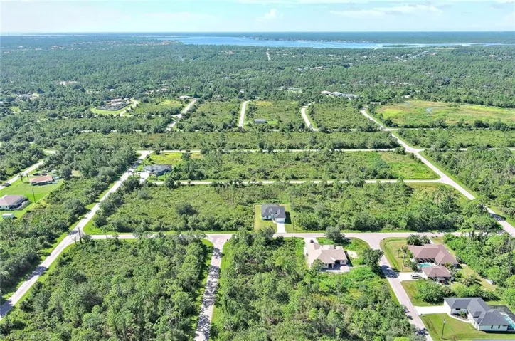 Aerial overview of property's location with a forest and a nearby body of water