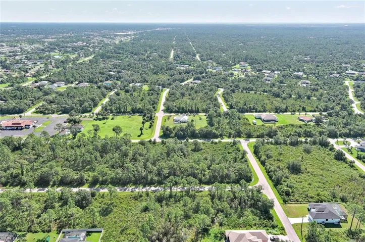 Aerial view of property's location featuring a heavily wooded area