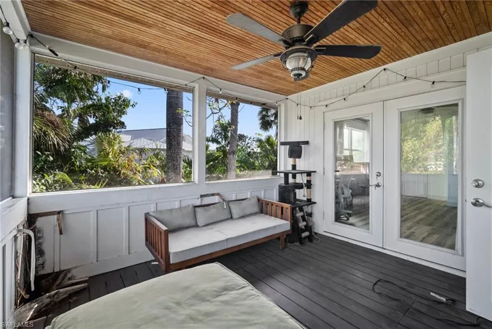 Unfurnished sunroom featuring french doors, ceiling fan, a healthy amount of sunlight, and wood ceiling